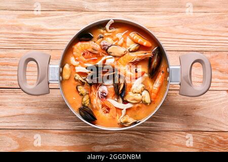 Topf mit leckerer Cacciucco-Suppe auf Holzboden Stockfoto