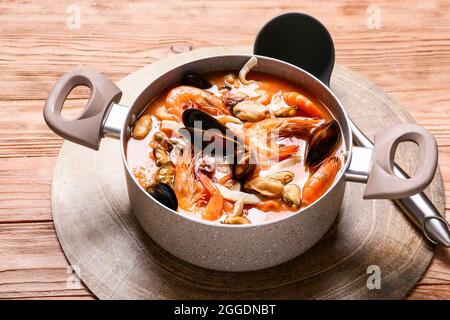 Topf mit leckerer Cacciucco-Suppe auf Holzboden Stockfoto