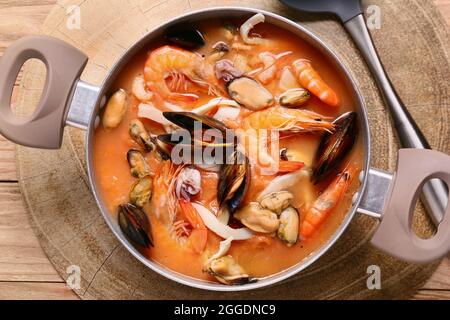 Topf mit leckerer Cacciucco-Suppe auf Holzboden Stockfoto