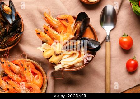 Schüssel mit leckerer Cacciucco-Suppe und Zutaten auf dem Tisch Stockfoto