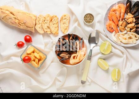 Schüssel mit leckerer Cacciucco-Suppe und Zutaten auf hellem Hintergrund Stockfoto