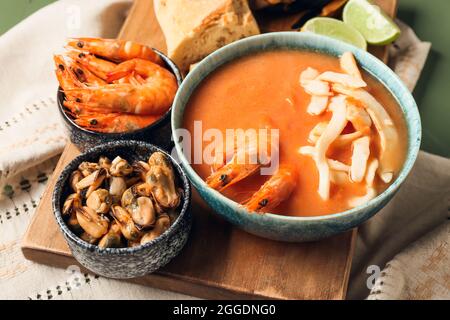 Schüssel mit leckerer Cacciucco-Suppe und Zutaten auf dem Tisch Stockfoto