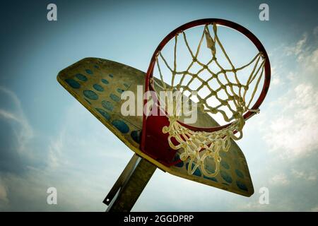 Basketballkorb vor blauem Himmel auf einem Platz im Freien, um bei Tageslicht sportliche Momente festzuhalten Stockfoto