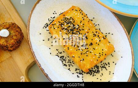 Gebratener Feta-Käse mit Kruste, Sesam und Honig, mediterrane Vorspeise Stockfoto