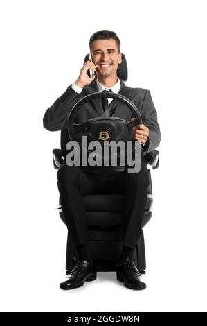 Geschäftsmann auf dem Autositz und mit Lenkrad, das auf weißem Hintergrund telefoniert Stockfoto