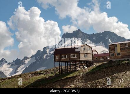 Holzhäuser in den Bergen. Neue Blockhütten im Hochland. Schöne Berglandschaft mit Wolken. Stockfoto