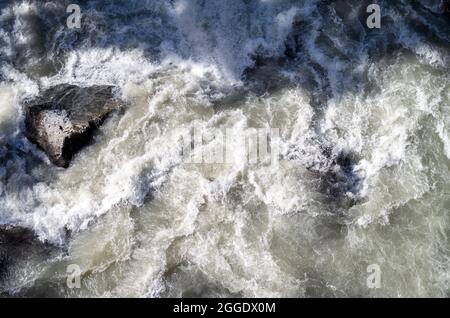 Der schnelle Fluss eines Gebirgsflusses von türkisfarbener Farbe.EIN schneller Fluss von Wasser aus dem Gletscher. Blick von oben. Stockfoto