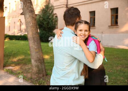 Vater sagt Auf Wiedersehen zu seiner kleinen Tochter in der Nähe der Schule Stockfoto