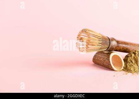 Matcha-Tee in Pulverform und Chasen auf farbigem Hintergrund Stockfoto