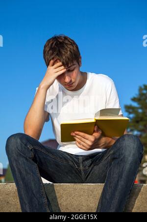 Unruhigen jungen Mann las ein Buch draußen Stockfoto