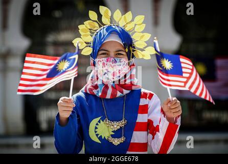 Kuala Lumpur, Malaysia. August 2021. Eine Frau, die malaysische Flaggen bei den Feierlichkeiten zum 64. Nationalen Tag in Kuala Lumpur hielt.Malaysia feiert seinen 64. Unabhängigkeitstag jährlich am 31. August und erinnert an die malaysische Unabhängigkeitserklärung vom 31. August 1957. Kredit: SOPA Images Limited/Alamy Live Nachrichten Stockfoto