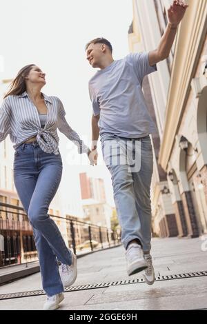 Porträt eines jungen glücklichen Paares in Bewegung. Spaziergang durch die Stadt an warmen, sonnigen Tagen Stockfoto