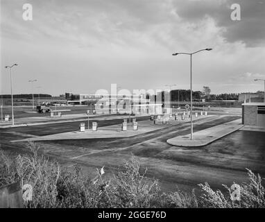 Blick nach Westen über das Keele Service Gebiet auf der Birmingham zur Preston Autobahn (M6), die im Vordergrund die Tankstelle und die Pumpen zeigt, im Hintergrund die Fußgängerbrücke über die Autobahn. Keele Services wurde vom Architekten Terence Verity entworfen und 1963 von Motorway Services Limited (Fortes) eröffnet. Stockfoto