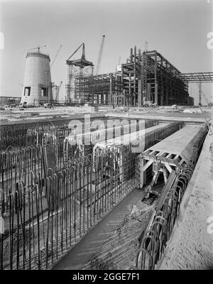 Ein Blick auf das Kraftwerk und den Hauptkamin während des Baus des Kraftwerks Isle of Grain, der die fünf Abgase für das Kühlwassersystem im Vordergrund zeigt. Das Isle of Grain Power Station war ein ölgefeuertes Kraftwerk, das in den Jahren 1970 &#x2019 von mehreren Auftragnehmern, darunter John Laing und Son Ltd., gebaut wurde.als das Kraftwerk 1979 eröffnet wurde, hatte es mit 244 Metern den zweithöchsten Kamin in Großbritannien. Das Kraftwerk wurde nun abgerissen und der Schornstein im September 2016 zerstört. An den s wurde ein neues CCGT-Kraftwerk (Combined Cycle Gas Turbine) errichtet Stockfoto