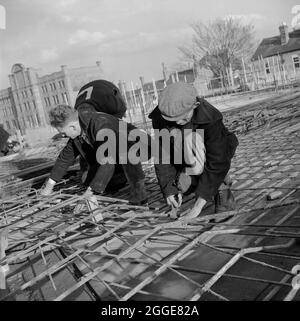 Arbeiter von Laing, die während des Baus der Kathedrale von Coventry Stahlverstärkungen am Boden des Kirchenschiffs befestigen. Dieses Bild wurde als Teil des Breaking New Ground Project in Zusammenarbeit mit dem John Laing Charitable Trust in den Jahren 2019-20 katalogisiert. Stockfoto