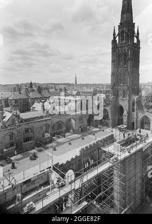Ein Blick nach Südwesten über die Ruinen der Kathedrale St. Michael vom Dach der neuen Kathedrale von Coventry aus, der im Vordergrund einen Teil der Baustelle neben der alten Kathedrale zeigt. Nach dem Bombenangriff auf die Kathedrale von Coventry im November 1940 wurde 1950 ein Wettbewerb gestartet, um einen Entwurf für eine neue Kathedrale zu finden. Das Siegerdesign stammt von Sir Basil Spence (1907-1976) aus einem von über 200 eingereichten Designs. Die Bauarbeiten fanden zwischen Mitte der 1950er und 1962 statt. Am 23. März 1956 legte Königin Elisabeth II. Den Grundstein. Stockfoto