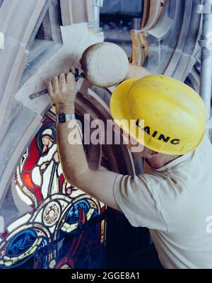 Ein Laing-Steinmetzer, der an der Restaurierung des Ostfensters in der Kathedrale von Carlisle arbeitet, steinerne Arbeiten steinernen, bevor ein neues Stück Stein mit dem vorhandenen Gewebe verbunden wird. Dieses Bild wurde als Teil des Breaking New Ground Project in Zusammenarbeit mit dem John Laing Charitable Trust in den Jahren 2019-20 katalogisiert. Stockfoto