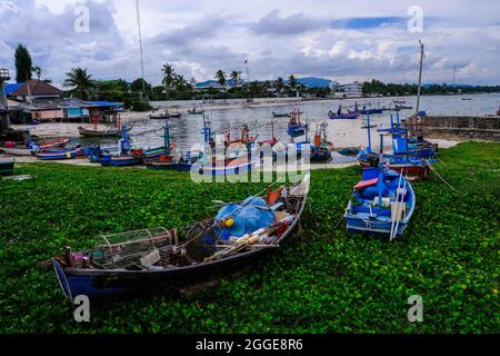 In Hua hin, Thailand, stehen verschiedene bunte thailändische Fischerboote am Strand und Meer fest Stockfoto