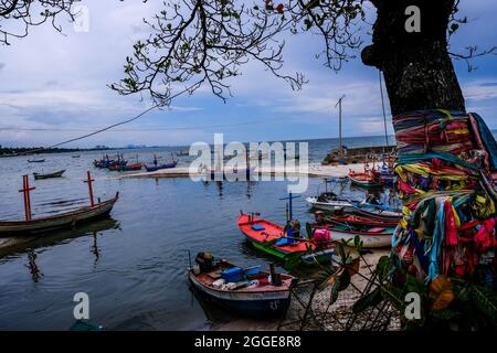 In Hua hin, Thailand, stehen verschiedene bunte thailändische Fischerboote am Strand und Meer fest Stockfoto