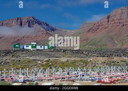 Friedhof, Gräber mit bunten künstlichen Blumen vor Bergen, Qeqertarsuaq, Disko Island, Qeqertarsuaq, Grönland Stockfoto