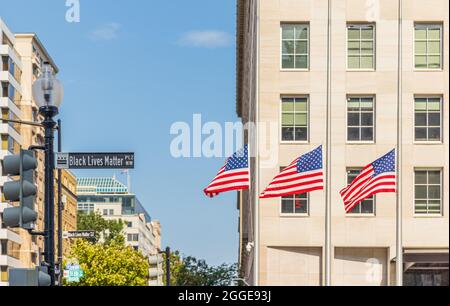 Washington, DC, USA - 14. August 2021: Straßenschild am neu benannten Black Lives Matter Plaza, mit amerikanischen Flaggen. Stockfoto