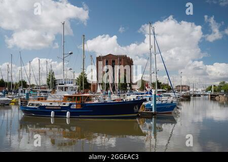 Segelboote und Yachten vor Anker mit Reflexionen unter wolkenverdunkelten Himmel an der Marina in Hull, Humberside, Großbritannien. Stockfoto