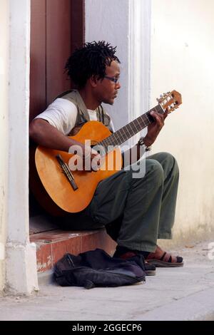 Der junge, dunkelhäutige Kubaner mit Rasta-Frisur sitzt vor der Tür und spielt Gitarre, die Altstadt-Hauptstadt Havanna, die Provinz Havanna, die Großantillen Stockfoto