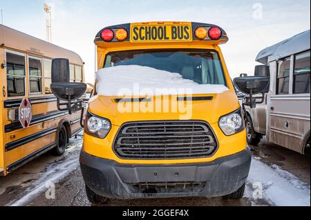 Geparkt am vorderen Ende eines Schulbusses, wobei die Windschutzscheibe nach einem Sturm mit Schnee bedeckt war Stockfoto