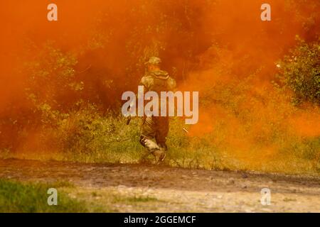 Fragment einer militärischen Demonstrationsvorstellung. Ein Soldat auf einem Rauchschirm trägt Signalbomben Stockfoto