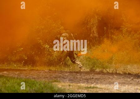 Fragment einer militärischen Demonstrationsvorstellung. Ein Soldat auf einem Rauchschirm trägt Signalbomben Stockfoto