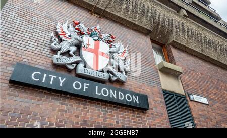 Stadtwappen von London. Die zeitgenössische heraldische Dekoration der historischen britischen Stadt auf der brutalistischen Architektur des Barbican Estate. Stockfoto