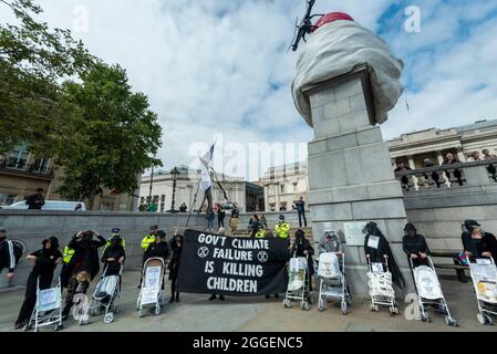 London, Großbritannien. 31. August 2021. Klimaaktivisten vom Extinction Rebellion, in Schwarz gekleidet und in Weiß gestrichene Kinderwagen, auf dem Trafalgar Square, um die Auswirkungen des Klimawandels auf Kinder hervorzuheben und die Regierung zu drängen, die Finanzierung fossiler Brennstoffe zu stoppen. Die Veranstaltung findet am 9. Tag des zweiwöchigen Protestes ‘Impossible Rebellion’ statt, um „die Ursache der Klima- und Umweltkrise anzuvisieren“. Kredit: Stephen Chung / Alamy Live Nachrichten Stockfoto