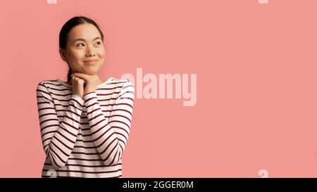 Tolles Angebot. Happy Cute Korean Lady Blick Beiseite Auf Copy Space Mit Erstaunen, Junge Asiatische Frau Halten Fäuste In Der Nähe Gesicht Und Denken Über Nizza Pro Stockfoto