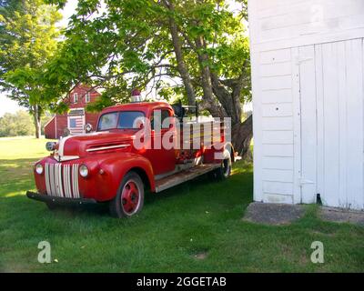 Alter Ford 1/2 Tonnen Pick up Feuerwehrmotor Truck1946-1947 durch eine alte Scheune, USA. Stockfoto