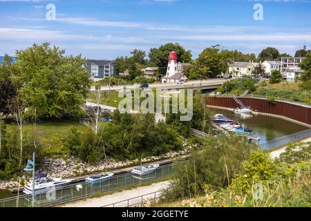 Boote, Die Auf Dem Penetangore River Festgemacht Sind, Fließen Zum Lake Huron In Kincardine, Ontario, Kanada. Der Historische Great Lakes Lighthouse Ist Sichtbar Stockfoto