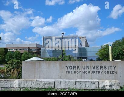 Toronto, Kanada - 30. August 2021: Blick vom Süden auf den Campus der York University, mit einem neuen Studentenzentrum und einem Steindenkmal mit Schild. Stockfoto