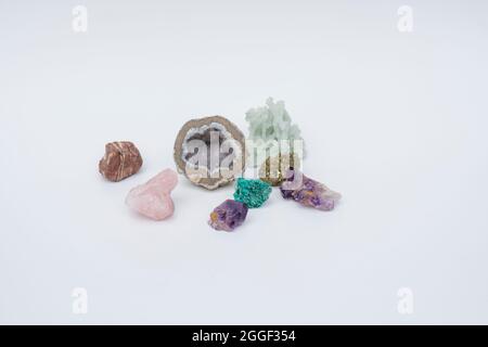 Bunte Schmucksteine wie Amethyst, Rosenquarz, Chrysocolla auf weißem Grund. Selektiver Fokus Stockfoto