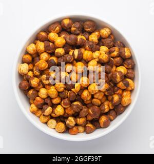 Nahaufnahme von Crunchy Roasted Chana Masala in weißer Keramikschale, hergestellt mit Bengalgrammen oder Kichererbsen. Indische, würzige Snacks (Namkeen), Blick von oben Stockfoto