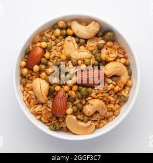 Nahaufnahme der Shahi-Mischung in einer weißen Keramikschale, hergestellt mit Erdnuss, Cashew, Mandeln. Indische, würzige Snacks (Namkeen). Draufsicht Stockfoto