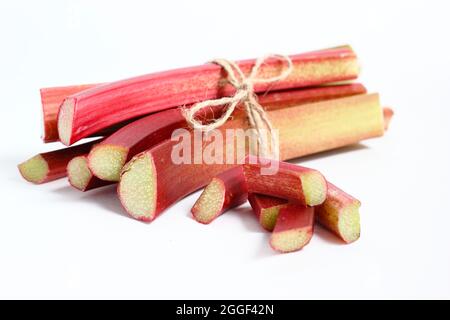 Rheum. Frisch gepflückte Rhabarberstämme isoliert auf weißem Hintergrund.UK Stockfoto