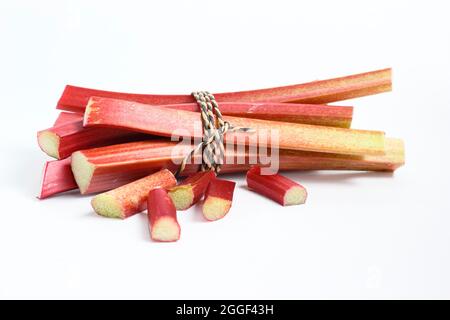 Rheum. Frisch gepflückte Rhabarberstämme isoliert auf weißem Hintergrund.UK Stockfoto