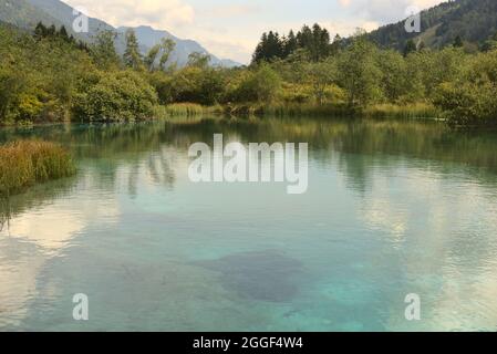 Quelle des Flusses Sava im Norden Sloweniens, der vor den umliegenden Hügeln einen kleinen See bildet Stockfoto