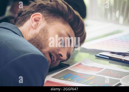 Der faule Arbeiter schläft erschöpft von einem müden Treffen. Eine Gruppe von Geschäftsleuten, die nach dem Meeting im Konferenzraum schlafen. Geschäftsführer und Stockfoto