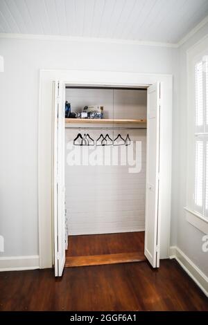 Ein leerer Schrank mit Kleiderbügeln in einer kleinen Kurzzeitmiete im Cottage-Stil Stockfoto