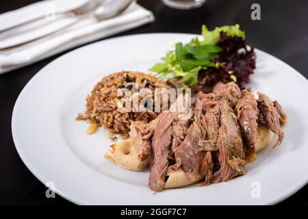 Die Tandoori-Lammkrone auf der Pita ist Tandoori. Kuzu Tandir Kebap. Pistazien und Johannisbeerreis. Stockfoto