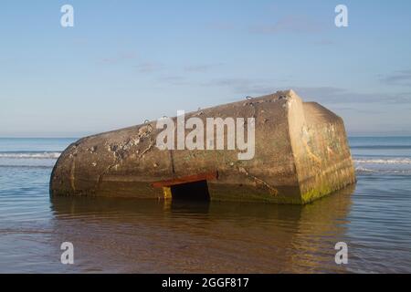 Alter deutscher Bunker aus dem zweiten Weltkrieg, der von den Dünen im ruhigen Meer im Tannis Bugt in Dänemark gefallen ist Stockfoto