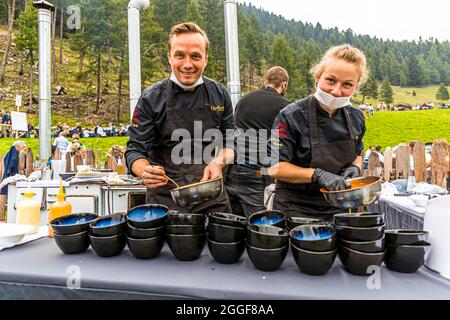 Unplugged Taste heißt das Gourmet-Event auf der Gomppm-Alm in Südtirol, Italien. Es findet jedes Jahr am letzten Sonntag im August statt. Berühmte Köche bereiten ihre Gerichte auf alten Holzöfen zu. Stockfoto