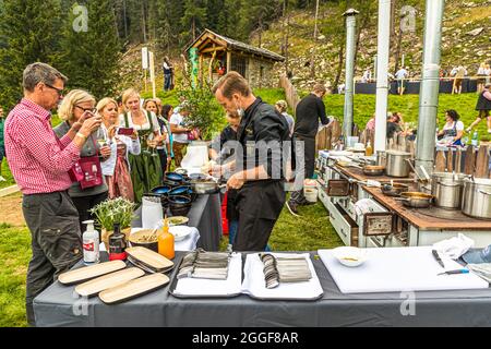 Unplugged Taste heißt das Gourmet-Event auf der Gomppm-Alm in Südtirol, Italien. Es findet jedes Jahr am letzten Sonntag im August statt. Berühmte Köche bereiten ihre Gerichte auf alten Holzöfen zu. Stockfoto