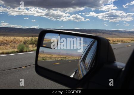 Blick in einem Autoflügel-Spiegel auf das Vermilion Cliffs National Monument, das entlang der Route 89A in der Nähe des Colorado River am Marble Canyon, Northern Ari, verläuft Stockfoto