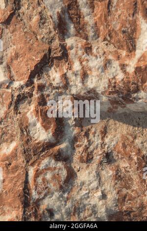 Die Textur des rohen mineralischen Marmors, helle Streifen auf dunklem Grund. Stockfoto